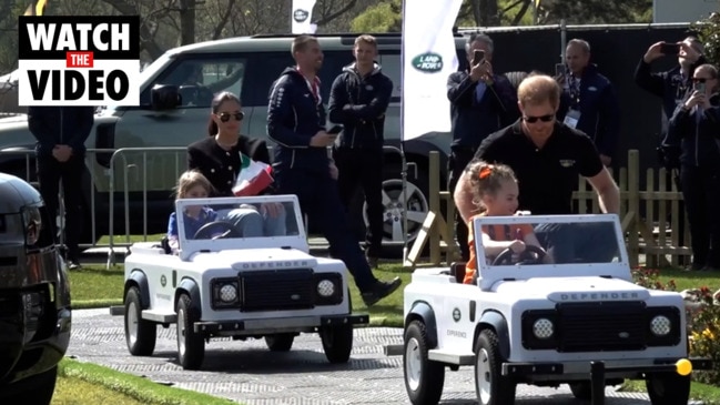 Harry and Meghan are taken for a spin on the Land Rover mini track