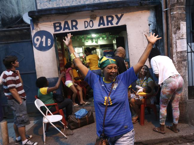 Brazilian soccer fan Graca, celebrates a Brazilian goal against Cameroon during the 2014 soccer World Cup at the Cantagalo favela in Rio de Janeiro, Brazil, Monday, June 23, 2014. Brazil's Neymar scored twice in the first half to lead Brazil to a 4-1 win over Cameroon on Monday, helping the hosts secure a spot in the second round of the World Cup. (AP Photo/Silvia Izquierdo)