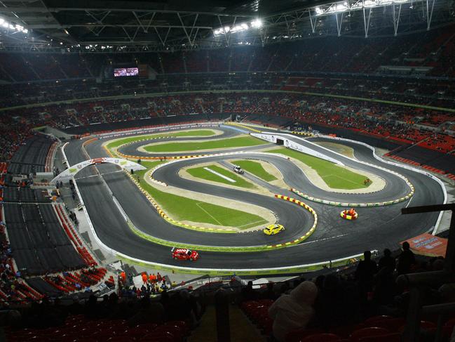 Two competitors compete in the Race of Champions at Wembley Stadium, London, Sunday Dec. 16, 2007. Seven-times Formula One world champion Schumacher was partnered by current Toro Rosso driver Sebastian Vettel as Germany beat Finland in the final in the end-of-year spectacular.The world's best drivers from various disciplines were in competition against one another on a giant 'Scalextric' track built inside the stadium. (AP Photo/Tom Hevezi)