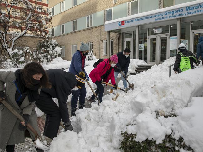 Neighbours clear the snow around Gregorio Maranon Hospital a day after the heaviest snowfall in decades in the Spanish capital, Madrid, on January 10, 2021. Picture: Getty Images