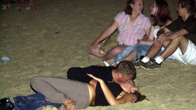 NOVEMBER 23, 2003 : A teenage couple kissing on the beach at Surfers Paradise during Schoolies Week