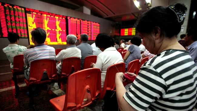 An investor knits while watching stock quotes at a securities trading firm in Shanghai, China, on Thursday, July 15, 2010. China's stocks dropped, led by commodity producers, after the nation's economic growth slowed in the second quarter. Photographer: Kevin Lee/Bloomberg via Getty Images