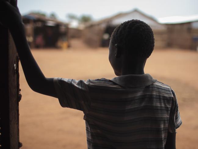 In this photo taken Saturday, May 13, 2017, thirteen-year-old boy Batista, who five months ago was drugged and raped in the middle of the night, stands in the doorway of a psychosocial support clinic in a camp for the internally-displaced in Wau, South Sudan. Four years into South Sudan's devastating civil war, the world's youngest nation is reeling from sexual violence on a "massive scale," a new Amnesty International report says Monday, July 24, 2017. (AP Photo/Bruno Bierrenbach Feder)