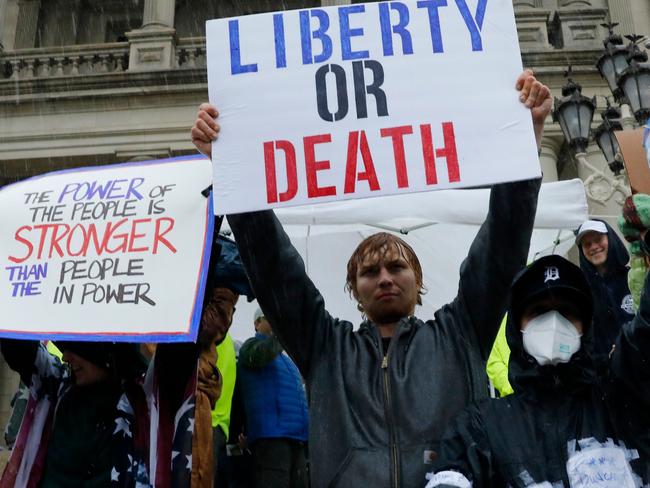 Demonstrators protest in Lansing, Michigan, during a rally organized by Michigan United for Liberty on May 14, 2020, to protest the coronavirus pandemic stay-at-home orders. - Michigan Governor Gretchen Whitmer said on May 13 that protests against the state's emergency orders might make it necessary for the state to keep restrictions in place longer. The orders have been extended until May 28. (Photo by JEFF KOWALSKY / AFP)