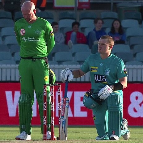 Ben Dunk stands while players take a knee before a BBL match.