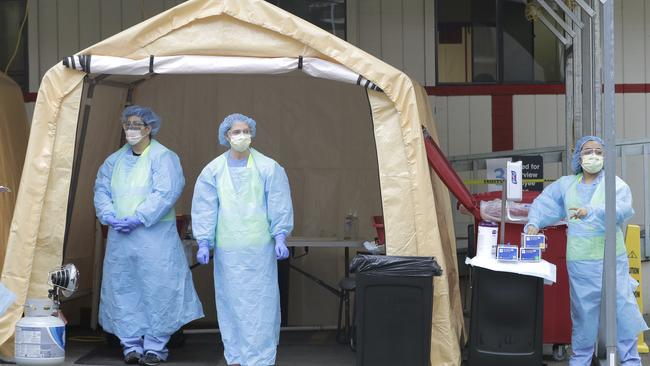 Nurses wait for cars at a drive-up coronavirus testing station. Picture: AP