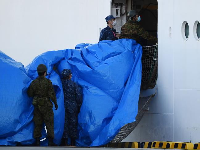 Military personnel set up a covered walkway next to the Diamond Princess. Picture: AFP