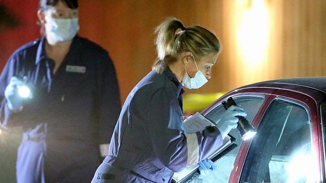 Police inspect a car parked outside the house. Picture: Mark Stewart