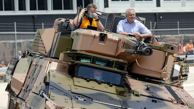 Scott Morrison, right, rides in a new Australian Boxer CRV at the opening of the Rheinmetall Military Vehicle Centre of Excellence in Redbank, Queensland, on Sunday. Picture: Sarah Marshall