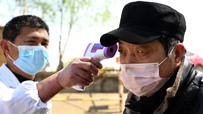 A passenger has his temperature checked before commuting on a boat in Jiujiang across the Yangtze river. Picture: AFP