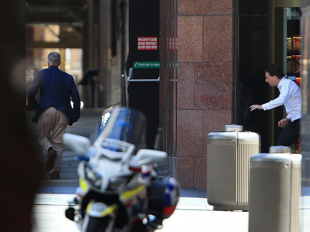 Two hostages escape out the front door of the Lindt cafe. Picture: Toby Zerna