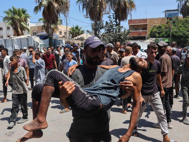 A Palestinian carries a man injured in Israeli bombardment to the Al-Aqsa Martyrs hospital in Deir el-Balah in the central Gaza Strip. Picture: AFP