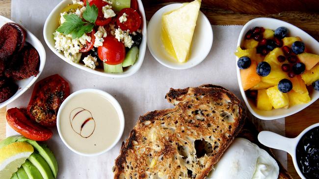 Sultan's Big Breakfast with poached eggs, tahinni, pekmez, sour cherry jam, cokelek cheese, nigella seeds, tomato, cucumber, avocado, fruit, lemon, toast and Anatolian sausage.