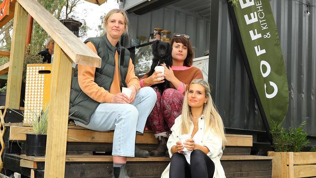 Locals residents are fighting to save a Jan Juc cafe which may close due to a council permit issue. Campaign organisers Jane Macdonald, left, Alex Sturman, holding her dog Creature, and Bree Schneider. Picture: Alison Wynd