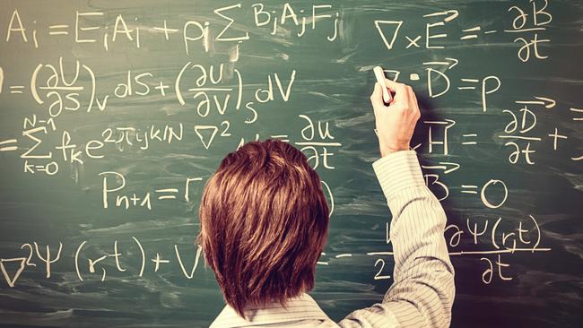 Newton's Equations. Rear view, close-up on young man standing back against green chalkboard. He explains, solves physics tasks, retro style. Processing for retro bleached look, slight vignette added.