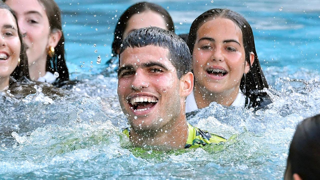 Spain's Carlos Alcaraz celebrates his victory taking a dip in the pool with ball girls and ball boys, after beating Greece's Stefanos Tsitsipas during the ATP Barcelona Open "Conde de Godo" tennis tournament singles final match at the Real Club de Tenis in Barcelona on April 23, 2023. (Photo by Pau BARRENA / AFP)