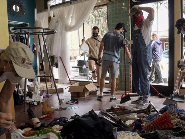 Volunteers and store owners clean up damage done to their stores, after demonstrations followed by unrest protesting the murder of George Floyd. Picture: AFP