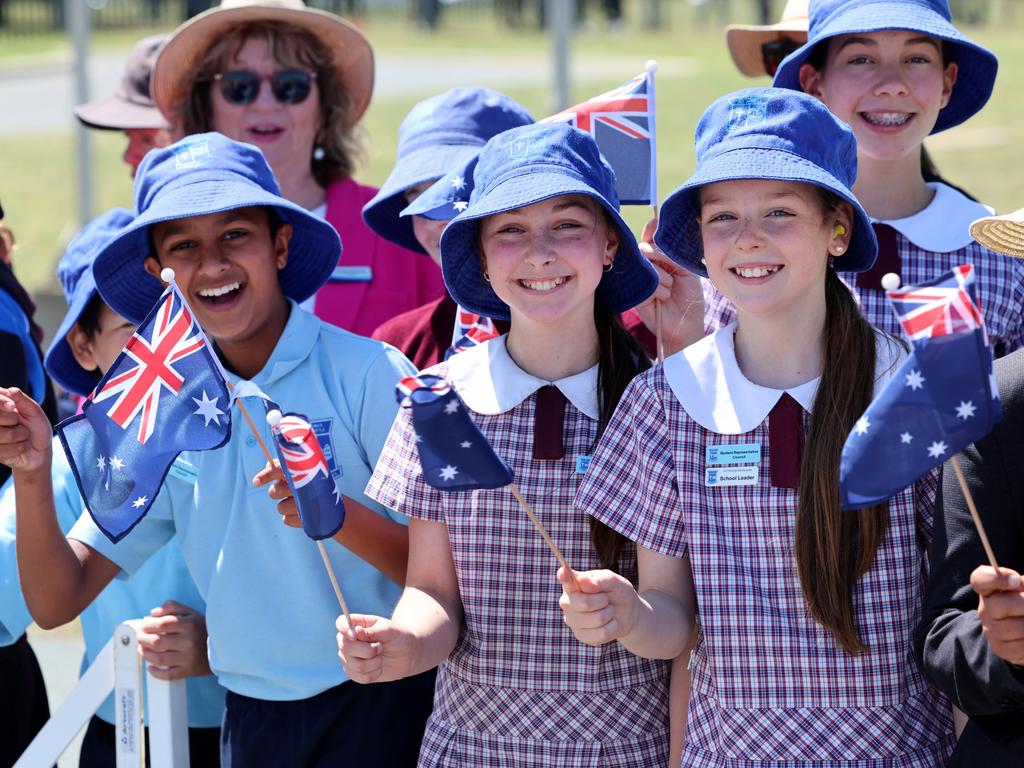 CANBERRA, AUSTRALIA - OCTOBER 21: Children wave flags as King Charles III and Queen Camilla arrive for a visit on October 21, 2024 in Canberra, Australia. The King's visit to Australia will be his first as Monarch, and CHOGM in Samoa will be his first as Head of the Commonwealth. (Photo by Chris Jackson/Getty Images)