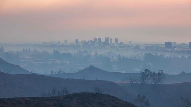 Burned trees and wildfire smoke from the Palisades Fire are seen from Will Rogers State Park with the City of Los Angeles in the distance. Picture: Getty