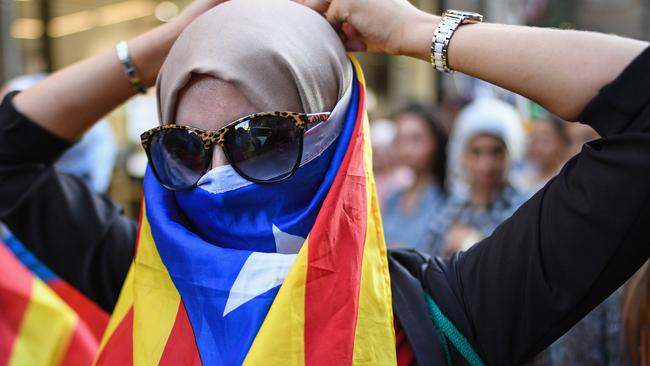 Moroccan Rif activists wrap themselves in a Catalan flag during a demonstration outside the Palau Catalan Regional Government Building on October 28, 2017 in Barcelona, Spain. Picture: Jeff J Mitchell/Getty Images