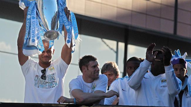 Captain Vincent Kompany shows of the trophy to fans.