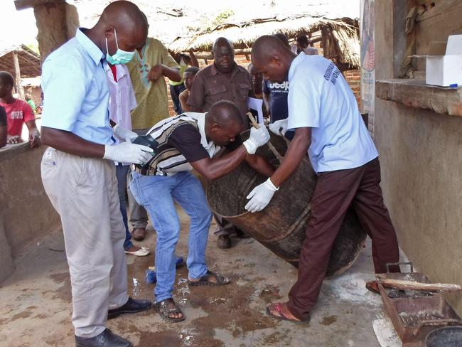 Mozambique officials gather samples from a drum that was used to brew the beer.