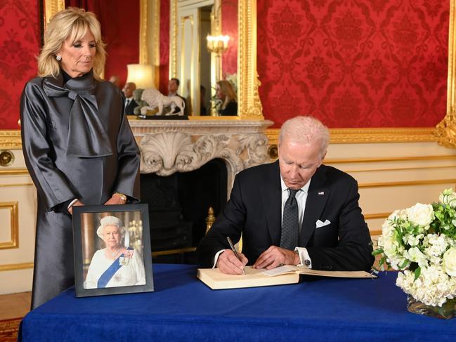 Joe Biden, watched on by wife, Jill, signs a book of condolence for the Queen. Picture: Getty Images.