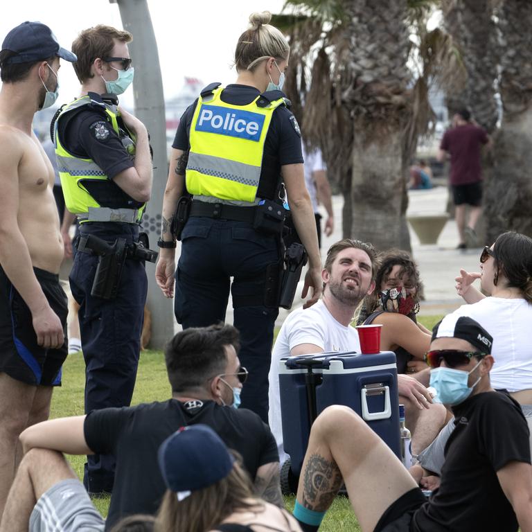 Police officers patrol among beachgoers at St Kilda on a Saturday afternoon to ensure they are wearing masks and obeying distancing rules. Picture: NCA NewsWire/David Geraghty