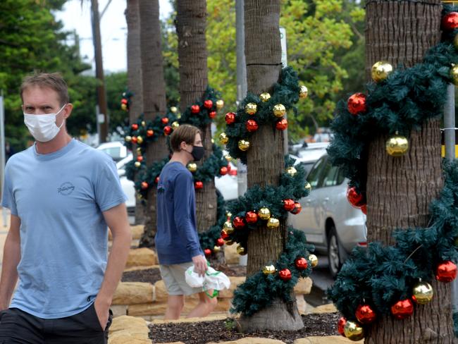 SYDNEY, AUSTRALIA - NewsWire Photos DECEMBER 20, 2020. Christmas decorations line the trees as locals wear masks through the streets of  Avalon this morning as SydneyÃs Northern Beaches enters day one of the lockdown. Picture: NCA NewsWire / Jeremy Piper