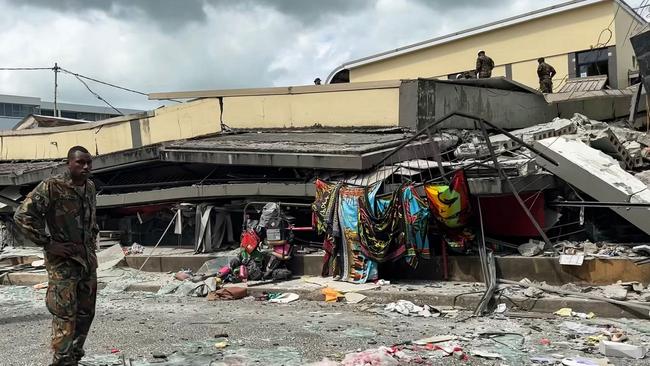 This screengrab taken from handout video footage posted on December 17 shows a member of security inspecting a collapsed building in Vanuatu’s capital Port Vila after a powerful earthquake hit the Pacific island. Picture: Michael Thompson/Facebook/AFP