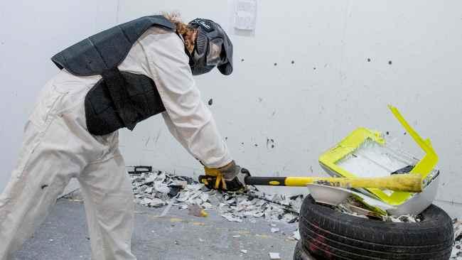 April Hard  destroying a printer at Smash Pit in Southport. Picture: Jerad Williams