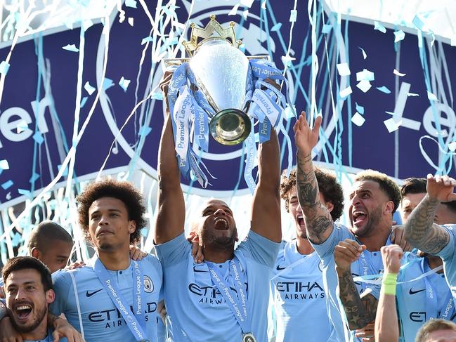 TOPSHOT - Manchester City's Belgian defender Vincent Kompany (C) holds up the Premier League trophy after their 4-1 victory in the English Premier League football match between Brighton and Hove Albion and Manchester City at the American Express Community Stadium in Brighton, southern England on May 12, 2019. - Manchester City held off a titanic challenge from Liverpool to become the first side in a decade to retain the Premier League on Sunday by coming from behind to beat Brighton 4-1 on Sunday. (Photo by Glyn KIRK / AFP) / RESTRICTED TO EDITORIAL USE. No use with unauthorized audio, video, data, fixture lists, club/league logos or 'live' services. Online in-match use limited to 120 images. An additional 40 images may be used in extra time. No video emulation. Social media in-match use limited to 120 images. An additional 40 images may be used in extra time. No use in betting publications, games or single club/league/player publications. /