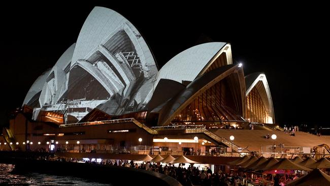 The sails of the Sydney Opera House is seen illuminated with a projection of video artwork to kick-off year-long celebrations for the landmark's 50th anniversary, in Sydney on October 19, 2022. (Photo by Muhammad FAROOQ / AFP)