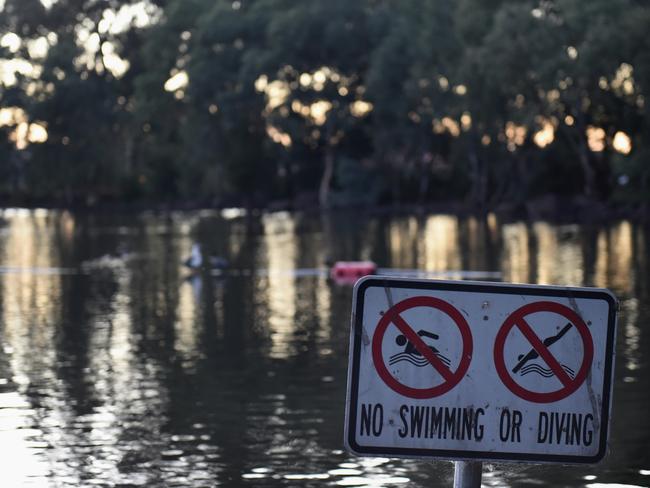 A sign warns people not to swim in the Miill Park lake where two men drowned. Picture: Nicole Garmston