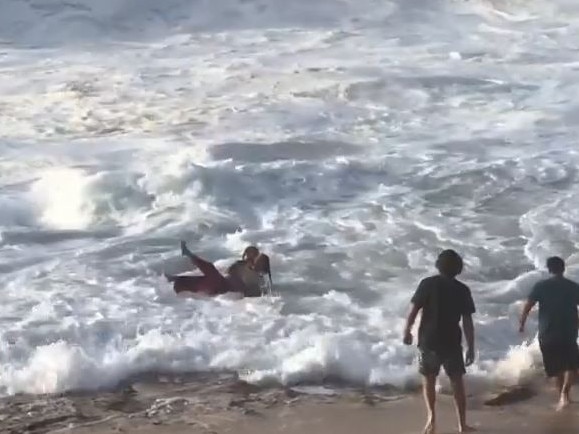 Footage shows Mikey trying to hold onto the woman as waves swept them across the rocks. Picture: Instagram