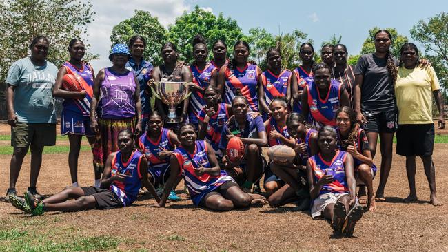 Player's from the Jikilarruwu Thunder &amp; Lightning women's side posing with the cup. Picture: Jono Laird.