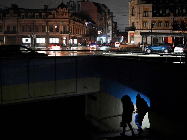 People use a flashlight as they enter an underground passage during a blackout following Russian strikes on the power infrastructure in Kyiv on December 17.