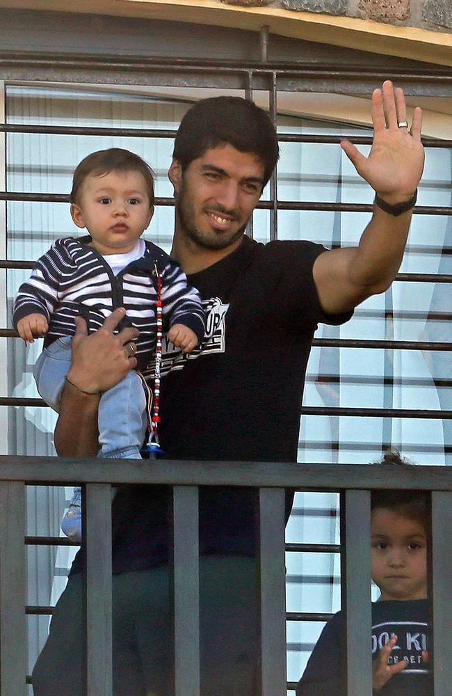 Uruguay's striker Luis Suarez greets fans from his mother's home in Lagomar.