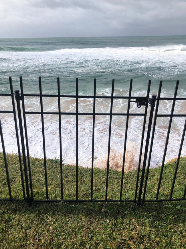 The Reeves' family, whose home backs on to Narrabeen Beach, had to install a fence to stop their small children from falling after beach erosion took away about three to five metres of their garden in three years. Picture: Julie Cross