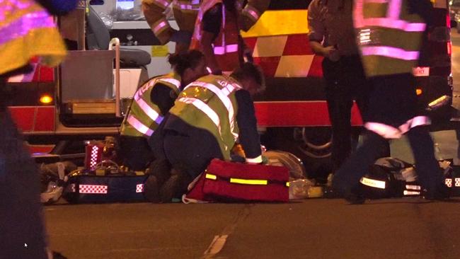 Paramedics treat one of the victims but both men died at the scene. Picture: TNV