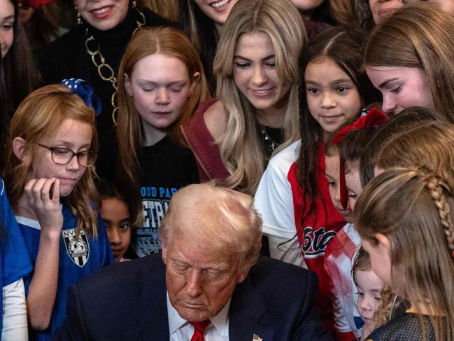 Young women and girls watch as US President Donald Trump signs the No Men in Women's Sports Executive Order in the East Room of the White House in Washington, DC, on February 5, 2025. President Trump on Wednesday is signing an executive order to ban transgender girls and women from competing on sports teams that match their gender identity, marking his latest move targeting transgender rights. (Photo by ANDREW CABALLERO-REYNOLDS / AFP)