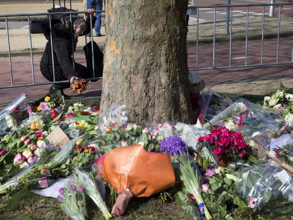A woman puts flowers at a makeshift memorial at the site of a shooting incident in Utrecht. Picture: AP 