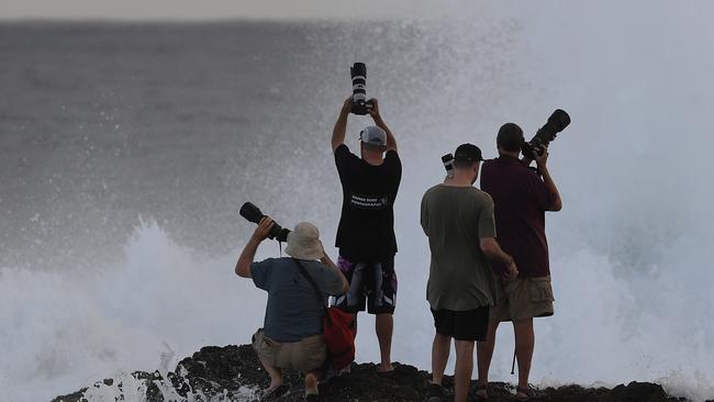 Photographers negotiate conditions at Snapper Rocks on the Gold Coast , Thursday February 21, 2019. Huge swells and high tides are set to pummelling south-east Queensland beaches over the coming days as Cyclone Oma tracks towards the Queensland coast. Photo: Dave Hunt/AAP.