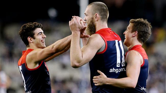 Max Gawn celebrates with Christian Petracca and Jack Trengove.