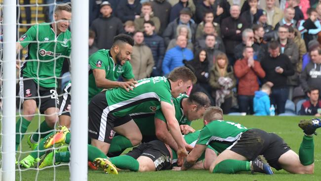 Lincoln City's English defender Sean Raggett (C) celebrates with teammates after scoring.