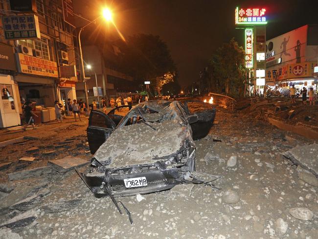 A crushed vehicle sits in rubble on a destroyed street after multiple explosions from an underground gas leak in Kaohsiung, Taiwan.