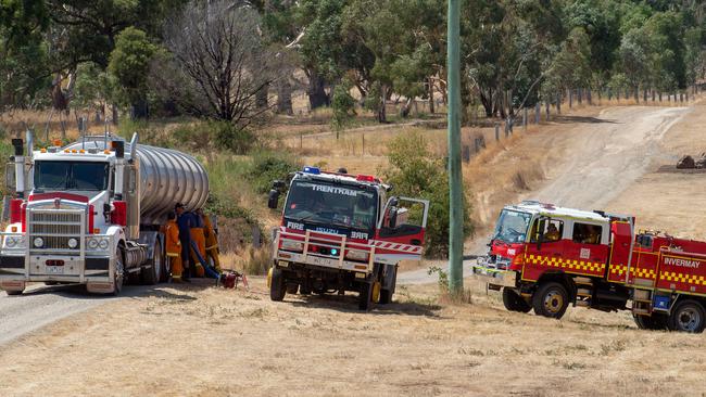 CFA trucks line up to refill with water from a tanker. Picture: Jay Town