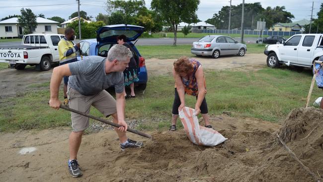 Barrister Craig Eberhardt helps out a resident with sand bags during the Shandee Blackburn murder trial.