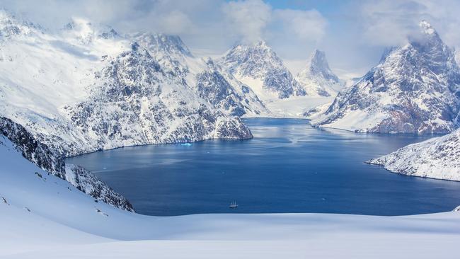 A sailing ship is dwarfed by the enormity of Evighedsfjorden in Greenland.