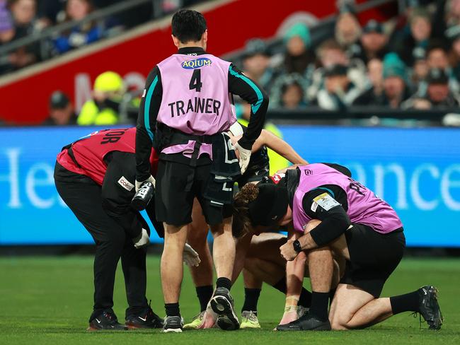 GEELONG, AUSTRALIA - AUGUST 05: Todd Marshall of the Power receives assistance under HIA protocol during the round 21 AFL match between Geelong Cats and Port Adelaide Power at GMHBA Stadium, on August 05, 2023, in Geelong, Australia. (Photo by Kelly Defina/Getty Images)